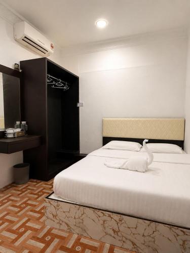 a bedroom with a white bed with a swan on it at OR Stay Semporna in Semporna