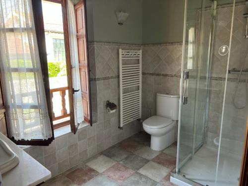 a bathroom with a toilet and a glass shower at Casa La Campa in Comillas