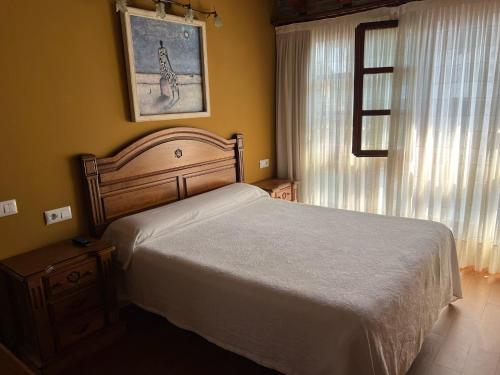 a bedroom with a white bed and a window at Casa La Campa in Comillas