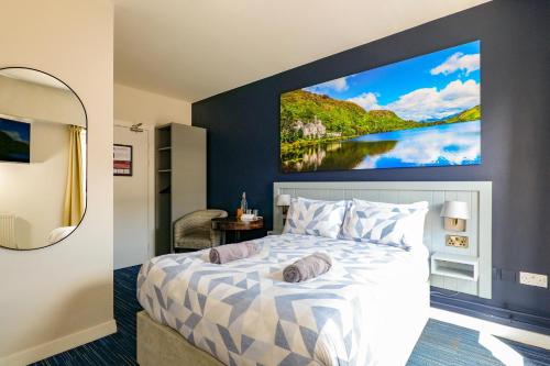 a bedroom with a bed with a large painting on the wall at Kinlay Hostel Eyre Square - Best Hostel in Ireland 2025 in Galway