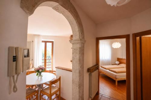 a kitchen with a table and a room with a bed at Appartamento Brione Lido in Nago-Torbole