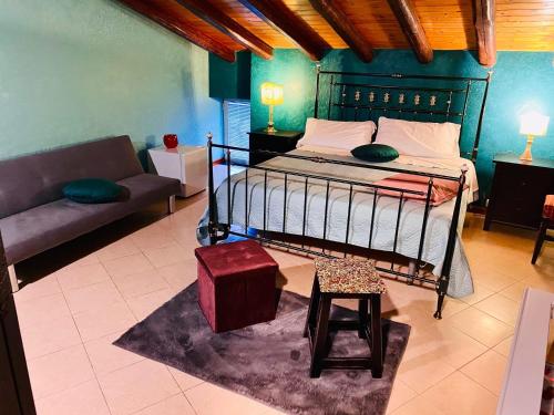 a bedroom with a bed and a couch in a room at Bianca di Navarra House in Biancavilla