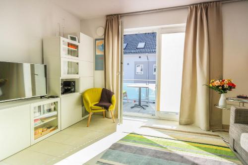 a living room with a yellow chair and a television at Sonnentraum in Zinnowitz