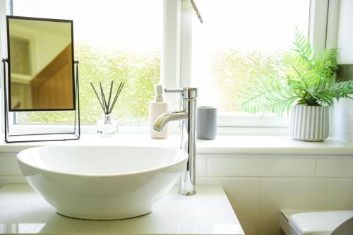 a white sink in a bathroom with a window at Ger Yr Afon in Saint Harmon