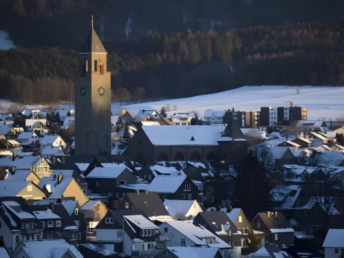 a town with a clock tower in the snow at Apartment Huckelberg in Schmallenberg