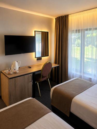 a hotel room with two beds and a desk at Hotel Bellevue in Skopje