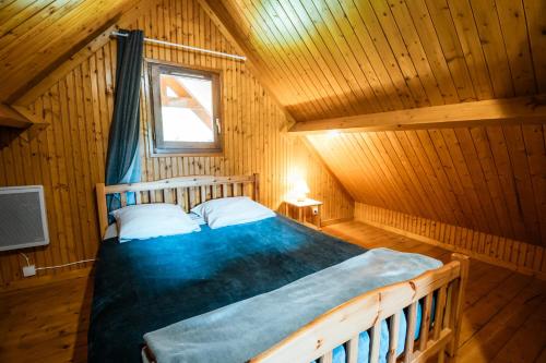 a bedroom with a bed in a wooden cabin at Domaine Guillaume Chalet 6p classic in Auquainville