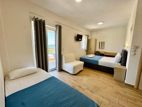 a hotel room with two beds and a window at Littore Maris in Nea Vrasna