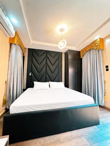 a bedroom with a large bed with a black headboard at The Movia Residences 1 in Enugu