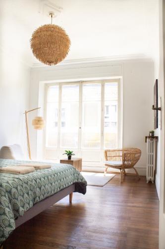 a bedroom with a bed and a large window at Avocado - Garage inclus - T3 - 96m2 - lumineux - Centre ville tout à pied in Grenoble