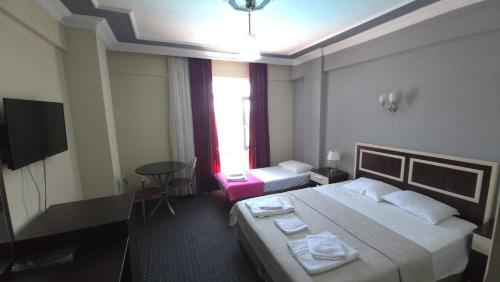 a hotel room with a bed and a television at AQUA MARMARA LİFE Hotel in Marmaraereglisi