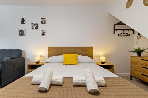 a bedroom with a large bed with a yellow pillow at Casa Los Sánchez in Alhaurín de la Torre