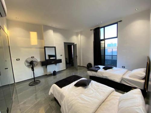 a hotel room with two beds and a fan at Ohio villa in Sowayma
