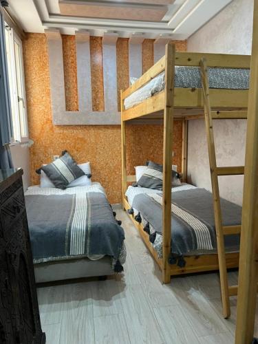 a bedroom with two bunk beds in a room at Abrid Surf in Tamraght Ouzdar