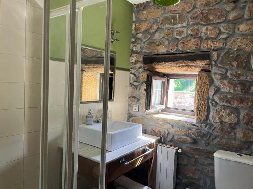 a bathroom with a sink and a stone wall at Posadaochohermanas in Las Fraguas
