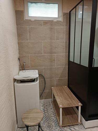 a bathroom with a sink and a wooden stool at Chez JF et ISA in Bussang
