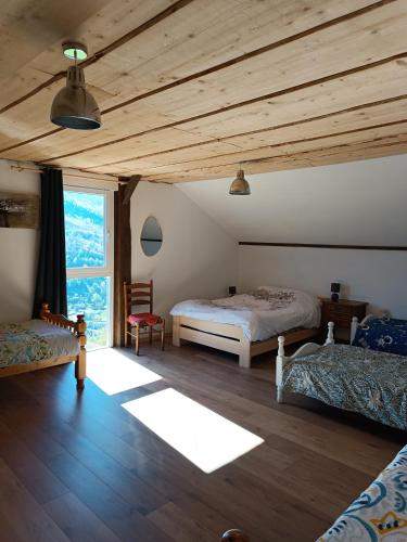 a bedroom with two beds and a wooden ceiling at Chez JF et ISA in Bussang