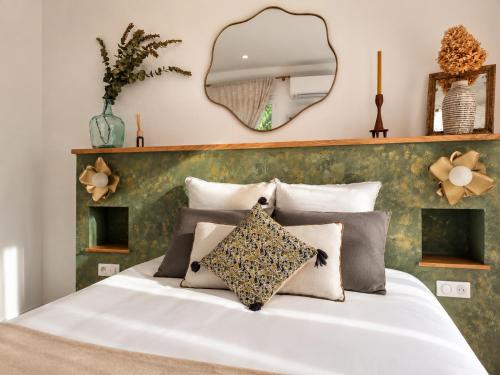a bedroom with a white bed with a mirror on the wall at Chambres d'hôte Casprese in Altiani