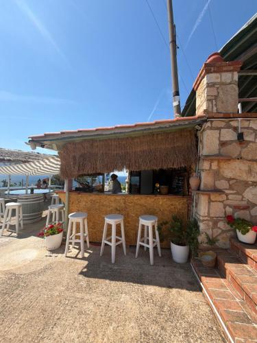 a bar with stools in front of a building at Hotel "SAN SAENA " in Vlorë