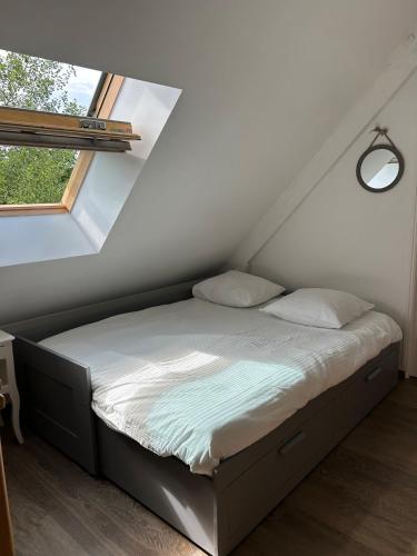 a bed in a small room with a window at La Bernache Solognote in Viglain