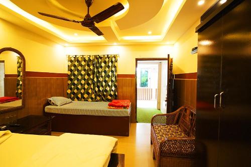 a room with two beds and a ceiling fan at Lake View Village Resort in Tajpur