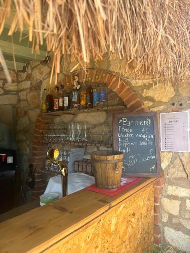a bar with a counter with a menu and a chalkboard at Hotel "SAN SAENA " in Vlorë