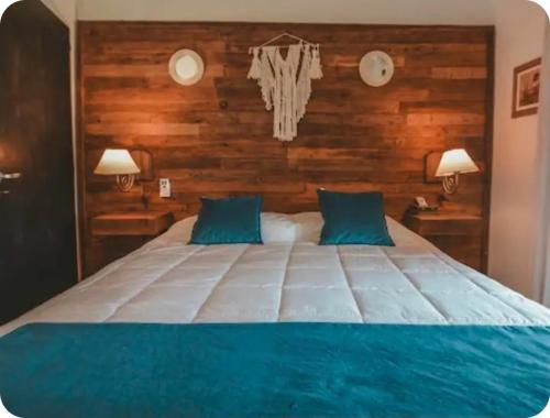 a large bed with blue pillows in a bedroom at El Madejo - del Valle de Uco in Tunuyán