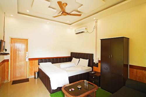 a bedroom with a bed and a ceiling fan at Lake View Village Resort in Tajpur