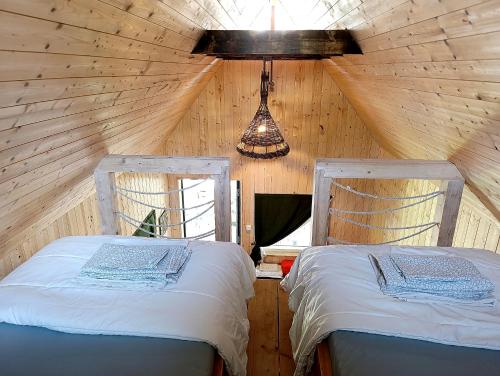a bedroom with two beds in a wooden cabin at Happy Hippy Cabin for 4 persons in Gataučiai