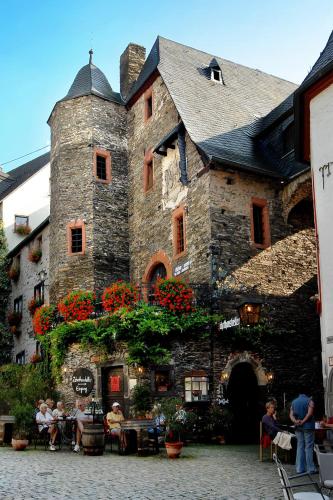 a large stone building with people sitting at tables at Villa Beilstein in Beilstein