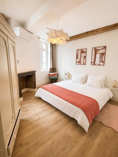 a bedroom with a large white bed with a red blanket at Maison hypocentre de Bethune in Béthune