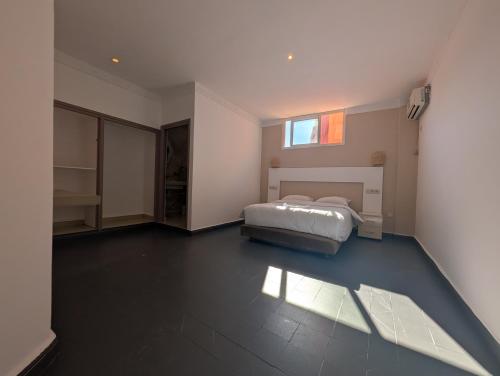 ein Schlafzimmer mit einem Bett und einem Fenster in der Unterkunft Side surfing in Aourir