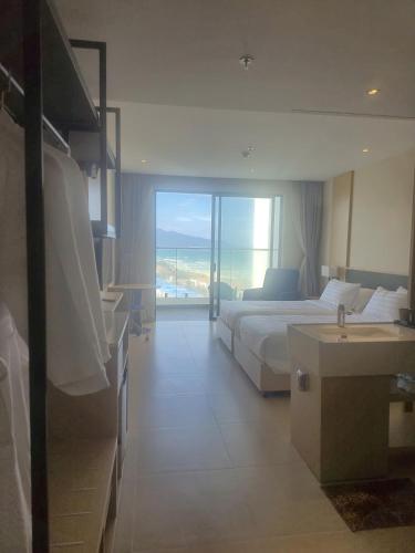 a bedroom with a bed and a bathroom with a sink at Arena Lucky Condotel in Cam Ranh International Airport