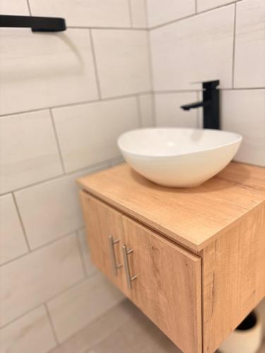 a bathroom with a white bowl sink on a wooden cabinet at Kilimanjaro in Alberton