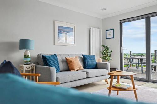 a living room with a gray couch and a table at Stylish 3 Bedroom with Balcony and Amazing View in Dollar