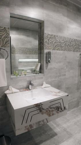 a bathroom with a white sink and a mirror at Daraysh Hotel 