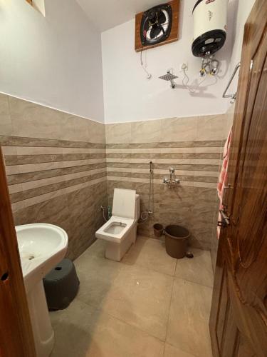 a bathroom with a toilet and a sink at Forest Breeze Homestay in Kanatal