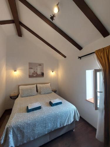 a bedroom with a bed with blue sheets and a window at House Belej - Lola in Belej