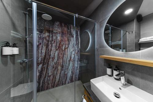 a bathroom with a shower and a sink at Hotel Sitno Forest Resort - Family friendly in Banská Štiavnica