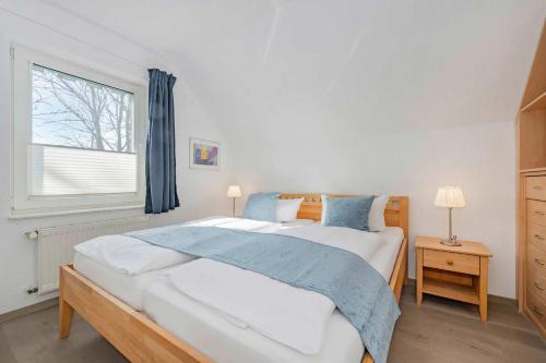a bedroom with a large bed and a window at Ferienanlage Seeblick Aquamarin in Koserow