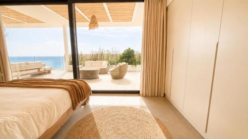 a bedroom with a bed and a view of the ocean at The Cliff Residences in Plomari