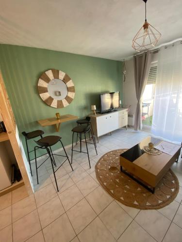 a living room with a table and chairs and a mirror at Studio cosy climatisé avec piscine parking Centre de Brignoles in Brignoles