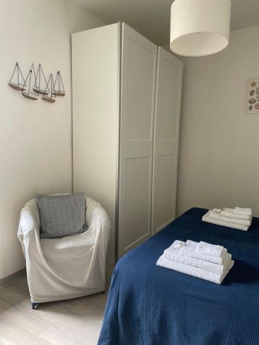 a bedroom with a bed and a chair and a closet at Appartamento La Fontina in Marciana Marina