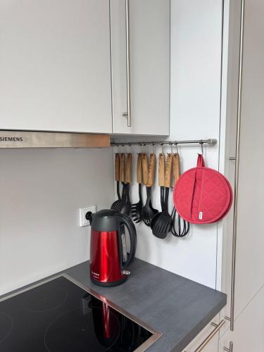 a red tea kettle and utensils on a kitchen counter at Brauhaus Suite 16 in Sebnitz