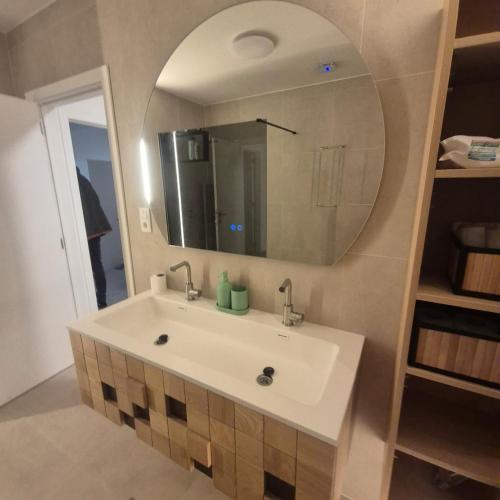 a bathroom with a white sink and a mirror at House for Tomorrowland in Rijweg