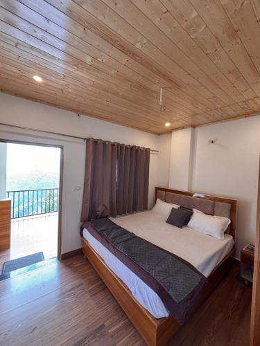 a bedroom with a bed with a wooden ceiling at Forest Breeze Homestay in Kanatal