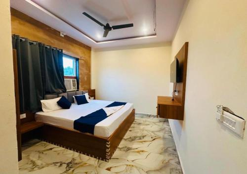 a bedroom with a bed and a television in it at Shri Hit Maya Dham in Vrindāvan