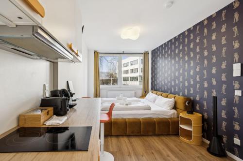 a small room with a bed and a desk and a kitchen at Arbio I Cube Studios & Apartments St Pauli in Hamburg