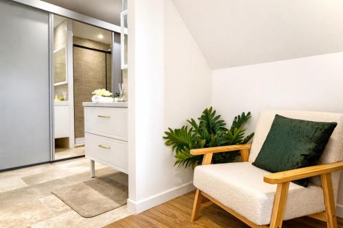 a living room with a chair and a plant at Les Arches d'Or - Loft 200 m2 avec Rooftop, Jacuzzi et 3 Suites - Centre 5 min - Proche A7-A9 in Orange