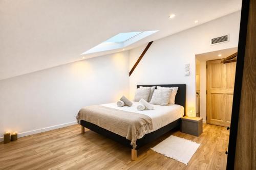 a bedroom with a bed with a skylight at Les Arches d'Or - Loft 200 m2 avec Rooftop, Jacuzzi et 3 Suites - Centre 5 min - Proche A7-A9 in Orange